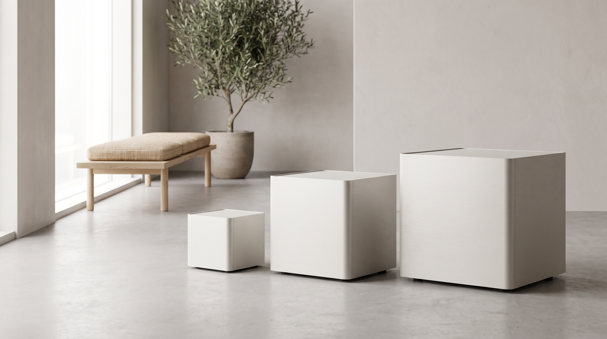 Three cube shaped air purifiers of graduated sizes in a bright minimal room