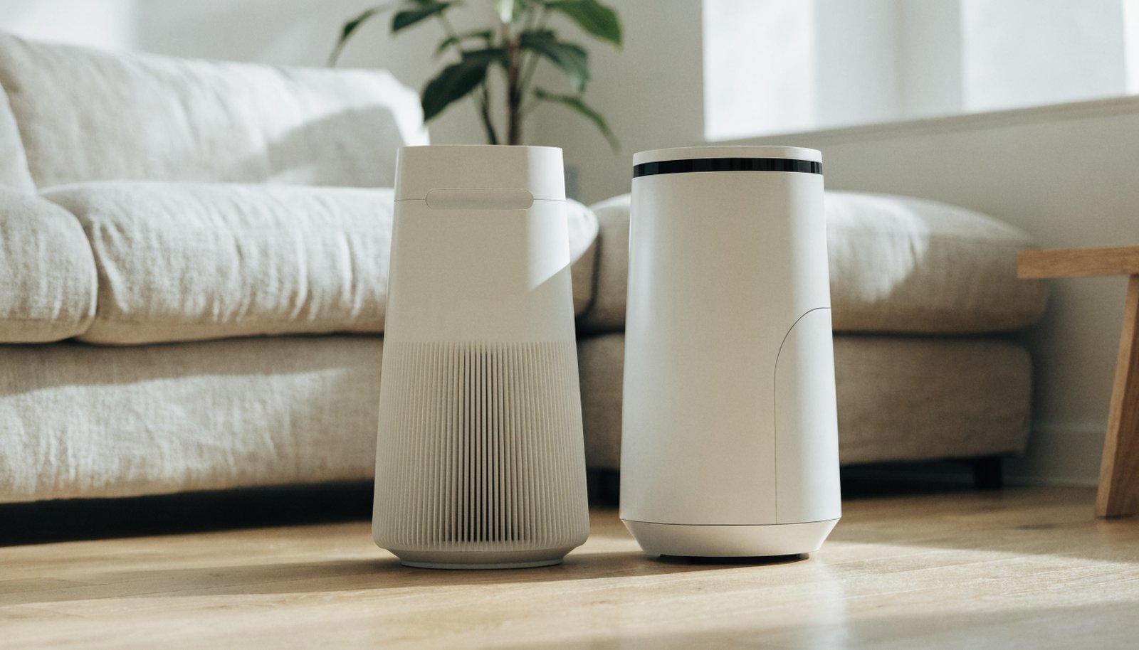Two tower air purifiers side by side in a bright living room